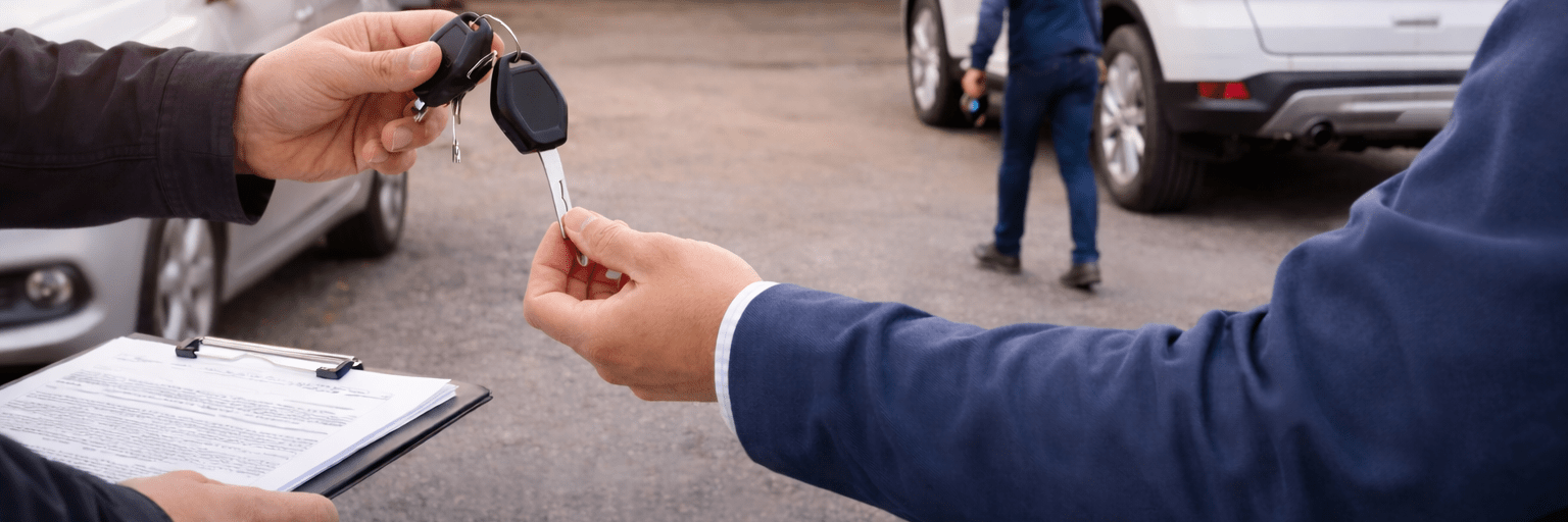 Autoschlüssel werden vor einer Kfz-Werkstatt übergeben – Hol- und Bringservice für Reparatur und Wartung ohne sichtbare Gesichter